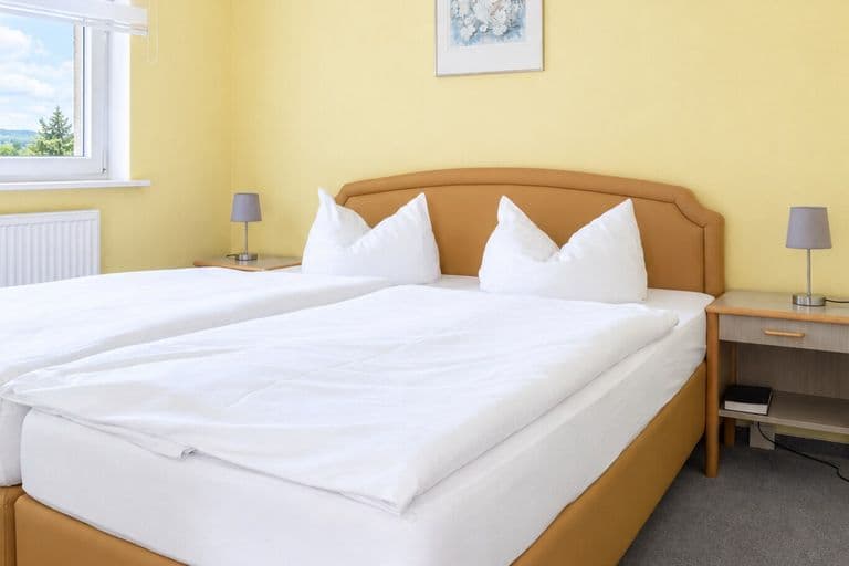 Schlafraum der Junior-Suite mit Doppelbett und Nachttischen