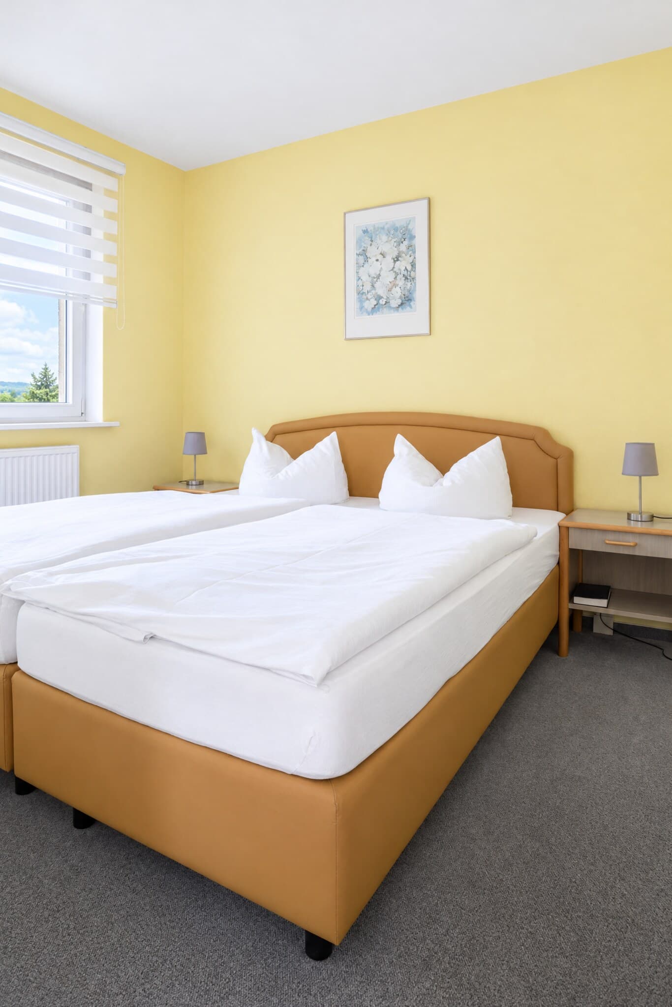 Schlafraum der Junior-Suite mit Doppelbett und Nachttischen