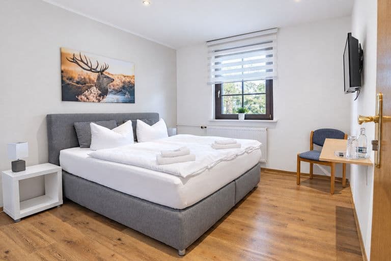 Familienzimmer: Schlafraum mit Boxspringbett und Hirschbild