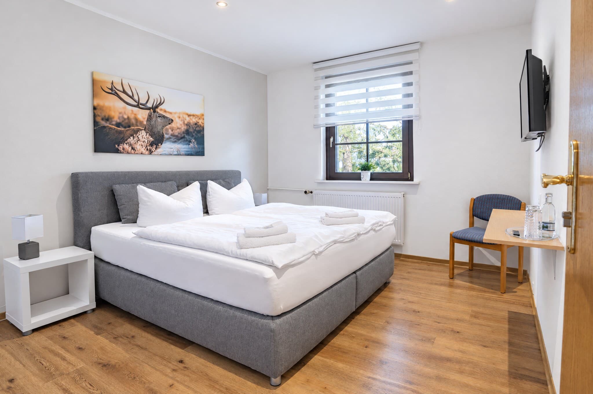 Familienzimmer: Schlafraum mit Boxspringbett und Hirschbild