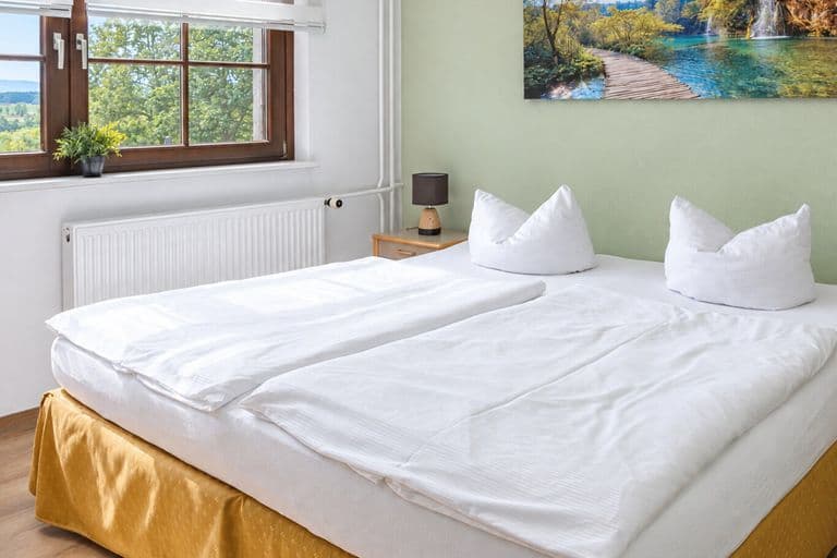 Komfortzimmer: Doppelbett im Morgenlicht