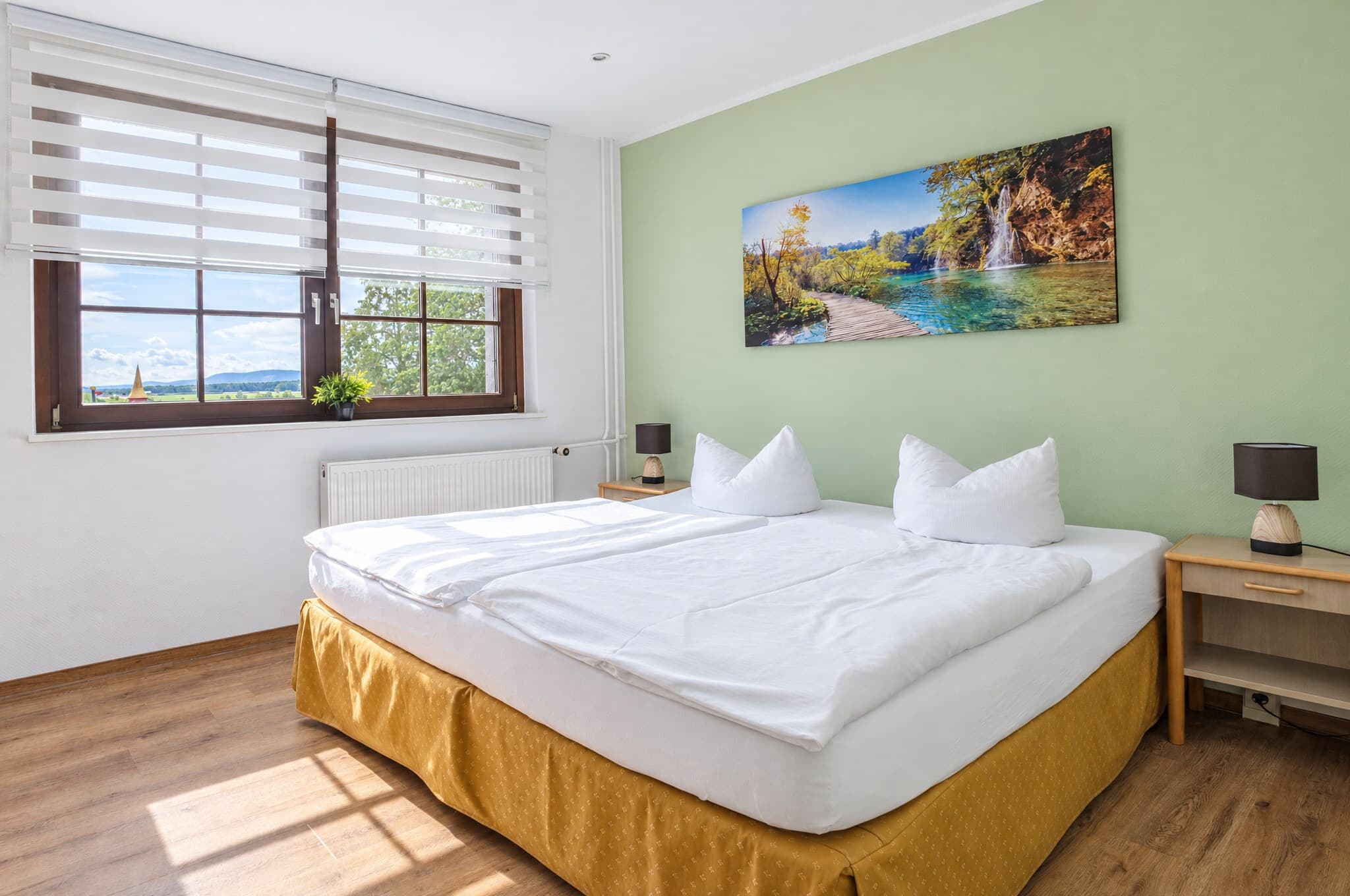 Komfortzimmer mit Doppelbett, Seebild und sonnigem Fenster