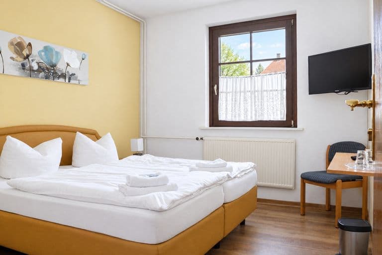 Familienzimmer mit Doppelbett und Sitzplatz am Fenster