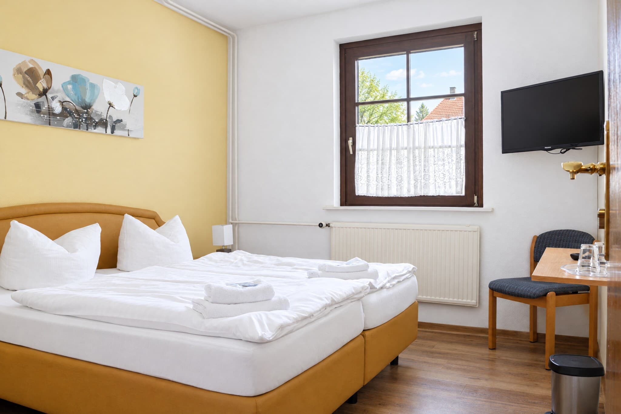 Familienzimmer mit Doppelbett und Sitzplatz am Fenster