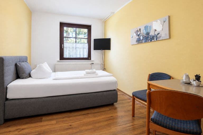 Familienzimmer mit Boxspringbett, Tisch und Fernseher