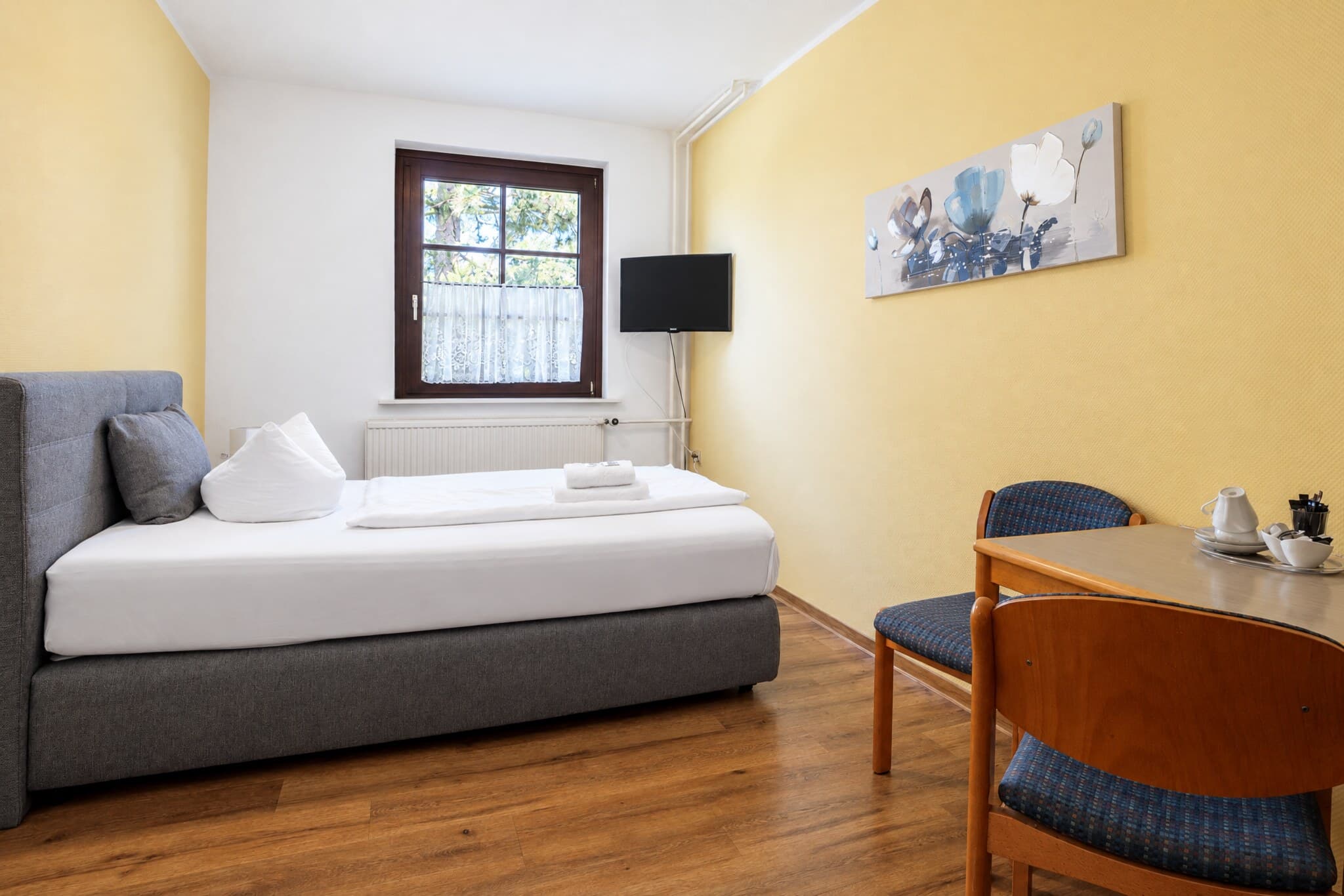 Familienzimmer mit Boxspringbett, Tisch und Fernseher