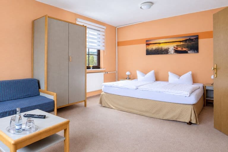 Junior-Suite mit Doppelbett, Kleiderschrank und Sitzecke