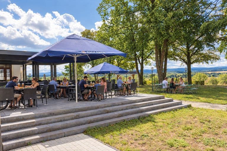 Terrasse mit Gästen und Blick über das Land zum Thüringer Wald