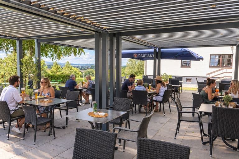 Überdachte Terrasse mit Gästen beim Essen