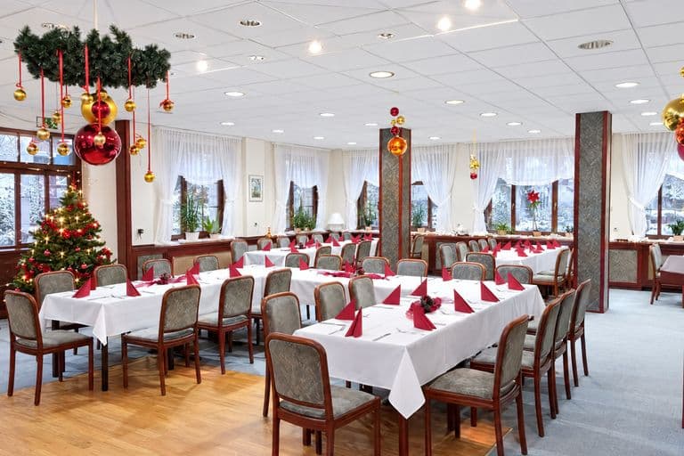 Saal mit weihnachtlich gedeckten Tafeln