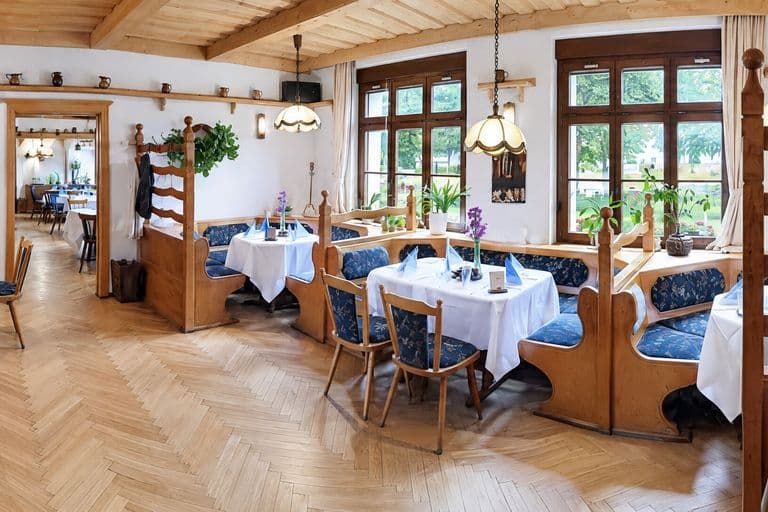 Weinzimmer im Panorama mit Holzdecke und gedeckten Tischen
